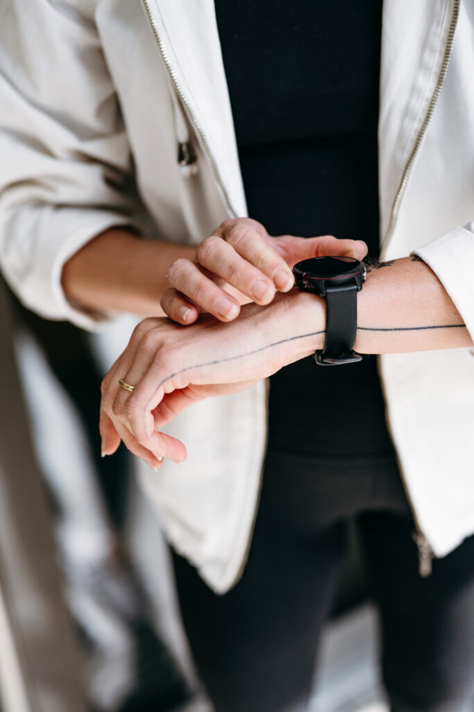 Woman in a jacket touching smart watch