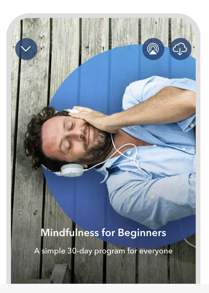 A man lying down smiling listening to headphones