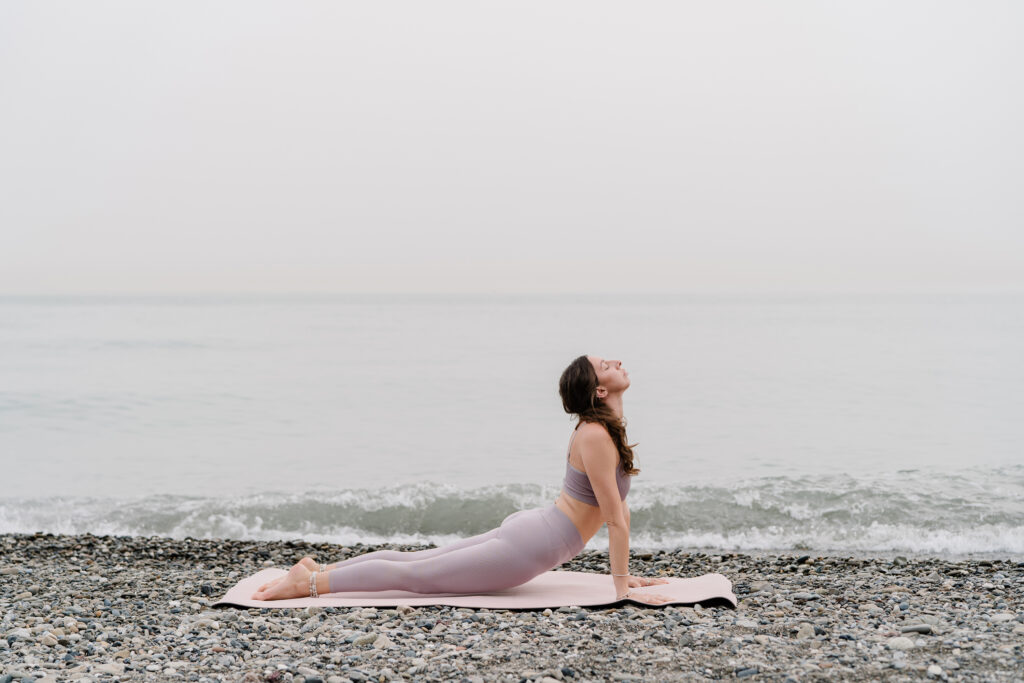 Woman doing the Cobra yoga pose at the beach