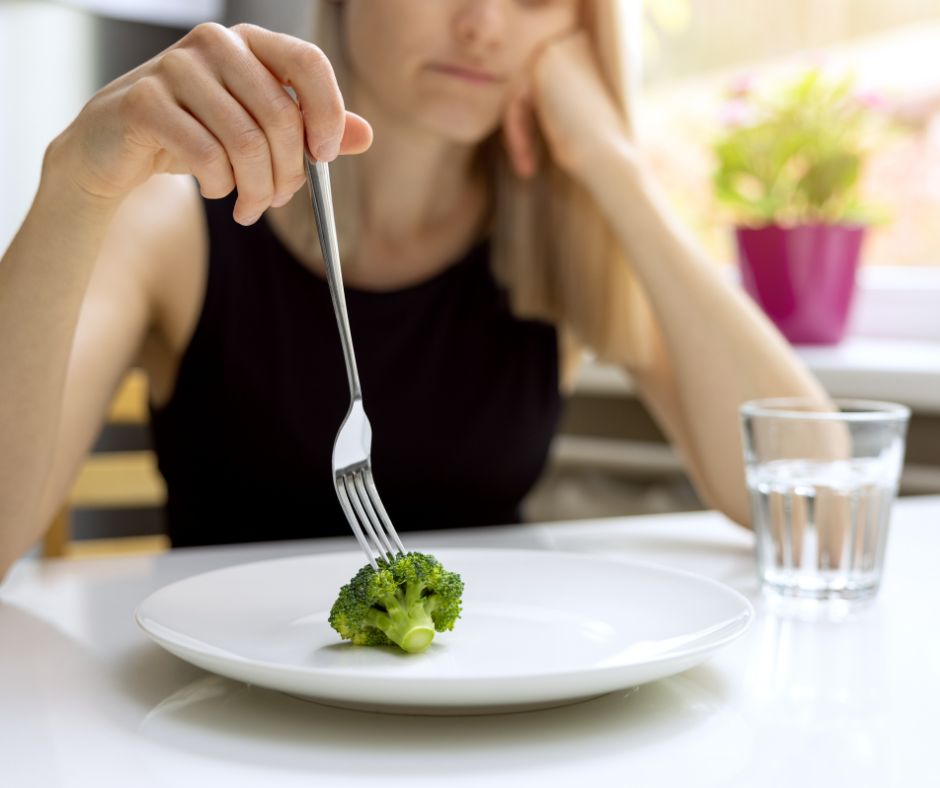 Woman with only one broccoli on a plate
