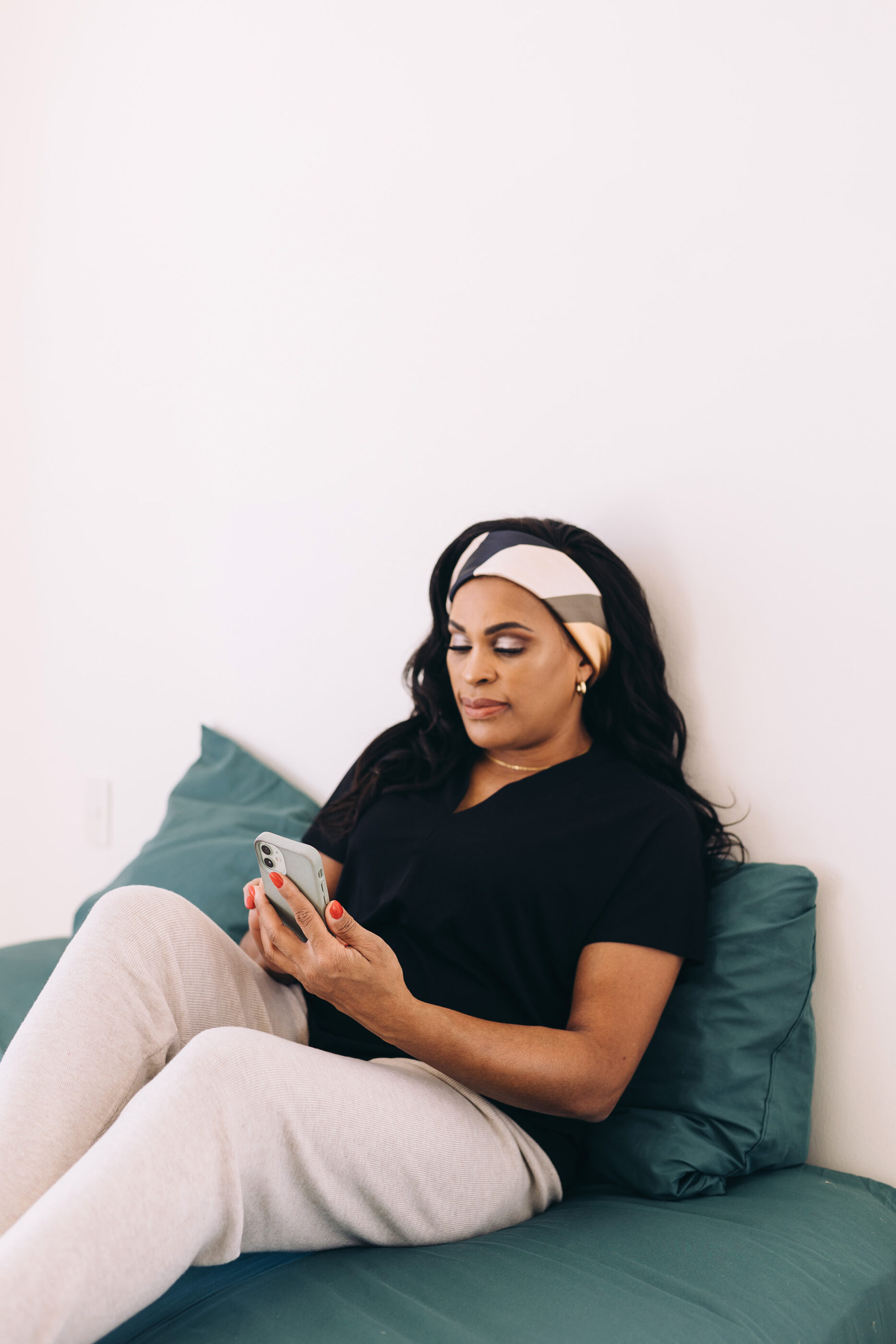 Black woman on couch looking at her phone